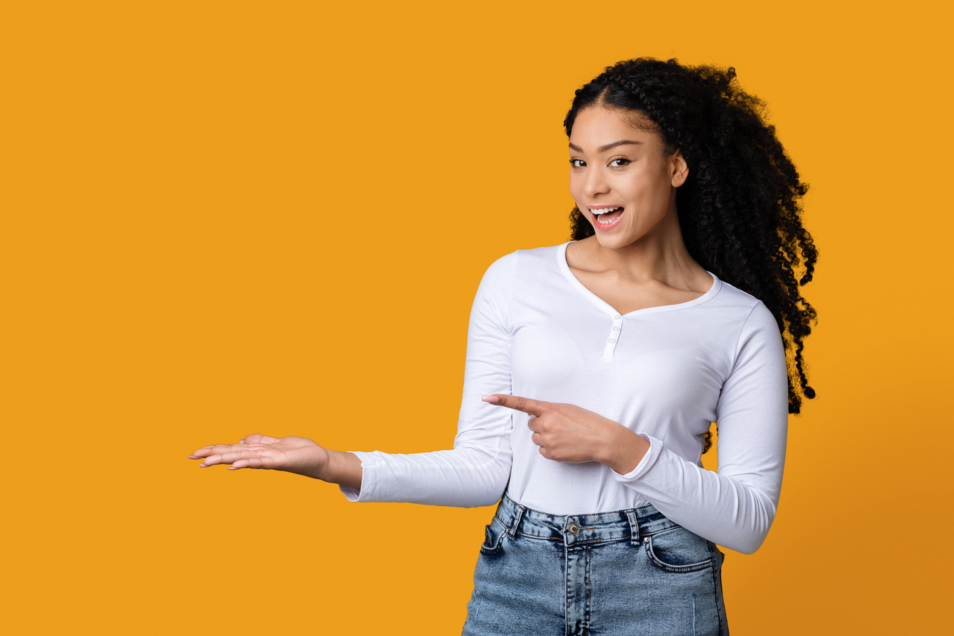 Cheerful Black Millennial Woman Pointing With Finger At Her Open Palm